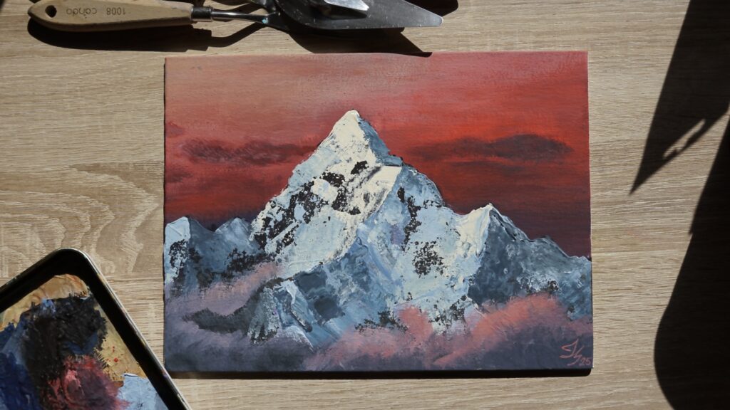 A textured acrylic mountain painting created during the Sip & Paint event at Toro Wine Bar in Tallinn, featuring a snowy peak against a vivid red sky
